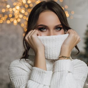 woman covering her face with sweater