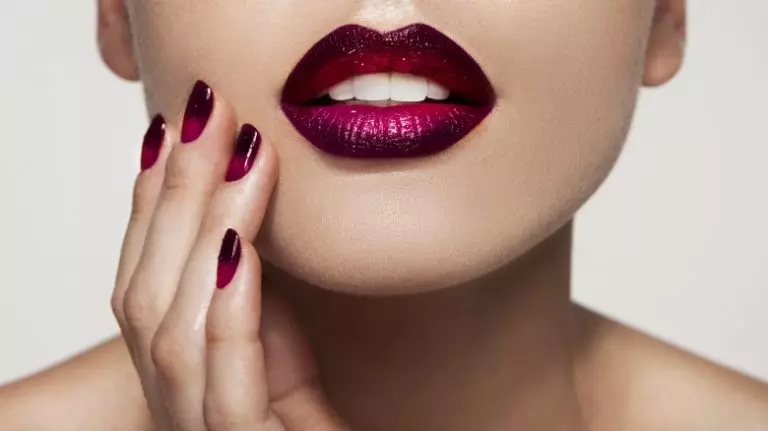 wine nail color polished nails against a woman's face