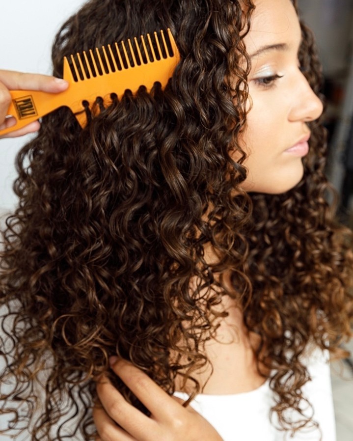 side shot of woman with curly hair at a salon