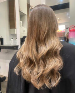 woman at Montreal's Salon Deauville with trending "bronde" hair color, a mixture of blonde and brown